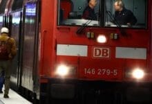 صورة لقطار ألماني حديث يقف في محطة، مع شاشة عرض إلكترونية تظهر رسالة خطأ أو عدم توفر الخدمة بسبب هجوم سيبراني استهدف شركة دويتشه بان.