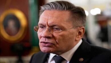 صورة توضيحية لرمز الطاقة النووية مع علمي روسيا وإيران في الخلفية، ترمز للتعاون النووي المحتمل بين البلدين.