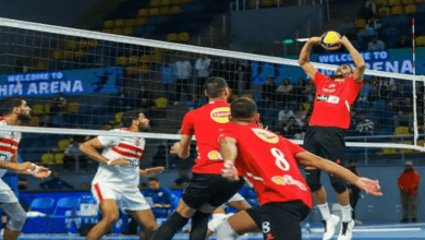 صورة تظهر لاعبين لكرة الطائرة يتنافسون على الكرة في مباراة حماسية.