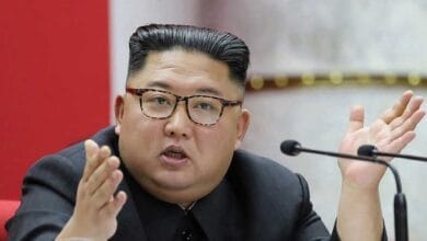 الزعيم الكوري الشمالي كيم جونغ أون يتفقد قاذفات صواريخ متعددة حديثة، ويرافقه مسئولون عسكريون رفيعو المستوى.