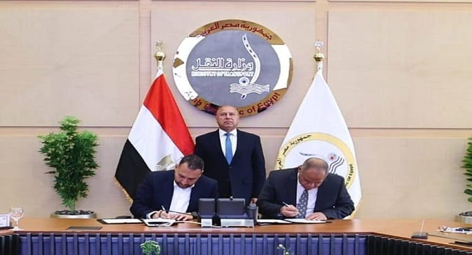 صورة لمعالي المهندس كامل الوزير، وزير النقل، وهو يصافح اللواء مهندس حسن الليثي والأستاذ محمد عزت بعد توقيع بروتوكول شراكة بين سوبر چيت وبوسطة لنقل الشحنات في مصر.