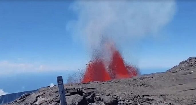 سياح يفرون بذهول بينما تتدفق الحمم البركانية وتفور من بركان "بيتون دي لا فورنيز" في جزيرة ريونيون الفرنسية، مع تصاعد الدخان والرماد.