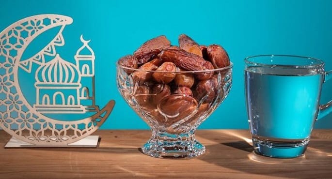 مجموعة من الأطعمة الصحية والمياه وكوب لقياس السكر، ترمز إلى الإرشادات الطبية لصيام صحي وآمن في شهر رمضان.