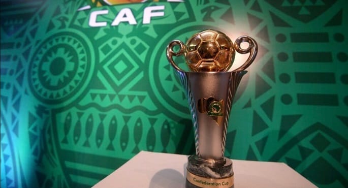 صورة لشعار كأس الكونفدرالية الأفريقية لكرة القدم، مع خلفية تظهر شعارات الأندية المشاركة في الدور ربع النهائي مثل الزمالك والمصري وشباب بلوزداد وأوتوهو.