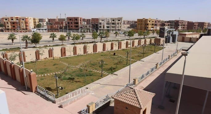 صورة عامة تظهر المهندسة راندة المنشاوي، وزيرة الإسكان والمرافق والمجتمعات العمرانية، وهي تتفقد موقع أحد المشاريع الإنشائية الضخمة في إحدى المدن الجديدة بصعيد مصر، محاطة بالمهندسين والمسؤولين، وتظهر في الخلفية معدات بناء حديثة وعمارات سكنية قيد الإنشاء.