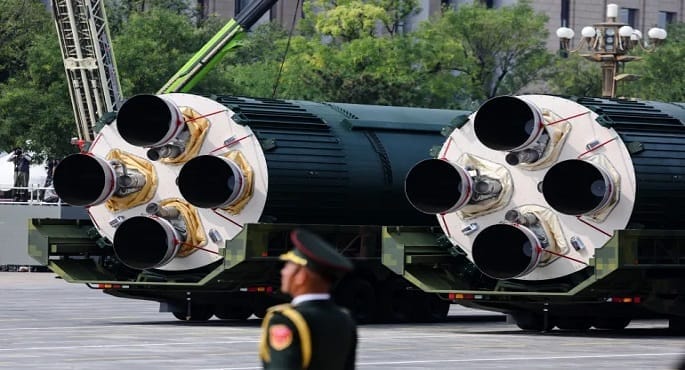 تصوير فني يظهر مقطعاً عرضياً للأرض مع انفجار نووي تحت الأرض، تنتشر منه موجات زلزالية، وقد تظهر خريطة رمزية تبرز الصين والولايات المتحدة لتمثل التوترات الدولية حول الأسلحة النووية.