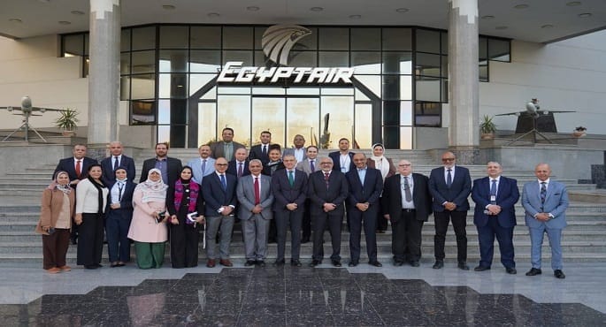 صورة شعار مصر للطيران الذهبي على خلفية زرقاء، مع شعارات شهادات الأيزو (ISO 9001, 14001, 45001, 10002) ترمز إلى الجودة والسلامة ورضا العملاء.