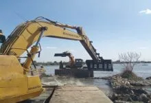 صورة جوية لنهر النيل في مصر تظهر بعض المناطق المتعدى عليها، مع آليات تعمل على إزالة المخالفات وضبط المجرى المائي.