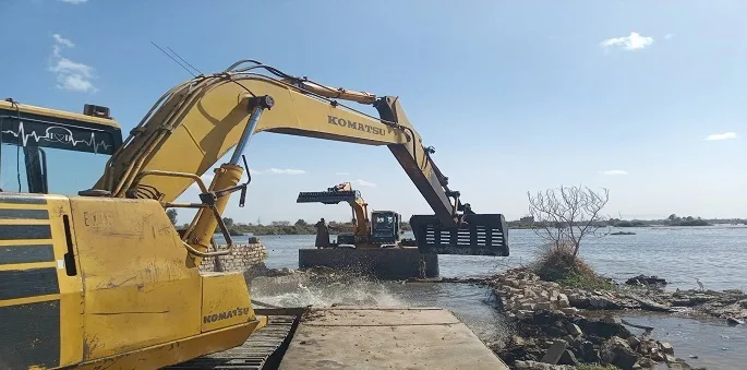 صورة جوية لنهر النيل في مصر تظهر بعض المناطق المتعدى عليها، مع آليات تعمل على إزالة المخالفات وضبط المجرى المائي.