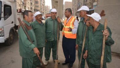 عمال نظافة يقومون بجمع المخلفات في أحد شوارع محافظة الجيزة.