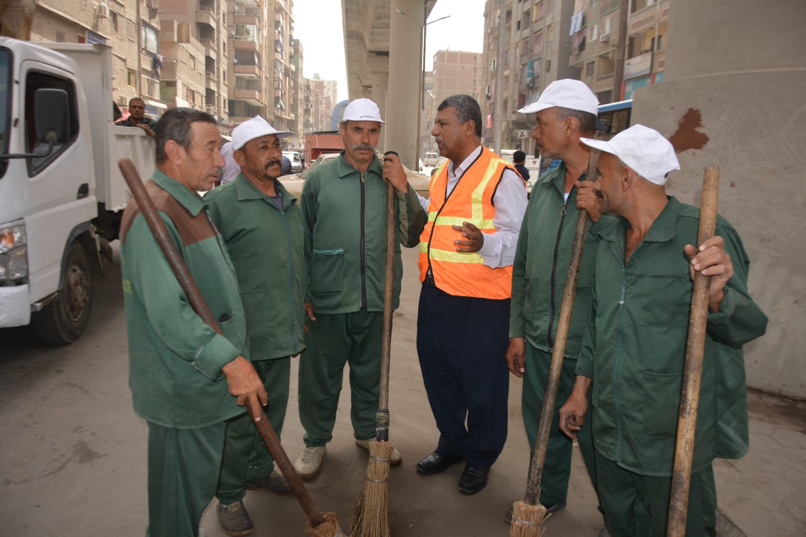 عمال نظافة يقومون بجمع المخلفات في أحد شوارع محافظة الجيزة.